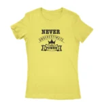 Image of a Daisy t-shirt with a white text graphic that reads 'NEVER UNDERESTIMATE THE POWER' with a crown symbol above the text, promoting a message of empowerment and resilience.