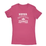 Image of a Heliconia t-shirt with a white text graphic that reads 'NEVER UNDERESTIMATE THE POWER' with a crown symbol above the text, promoting a message of empowerment and resilience.