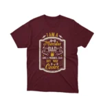 A Maroon tee with 'Muscular Dad' text, celebrating cool dads everywhere, from Apparel by Cetakshop.