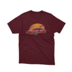 A Maroon tee with a classic car under a sunset design, from Apparel by Cetakshop, for vintage car lovers.