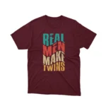 A playful 'Real Men Make Twins' slogan on a maroon graphic tee from Apparel by Cetakshop, ideal for dads with a sense of humor.