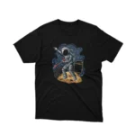 A Black tee showcasing an astronaut with a hitchhiker sign, by Apparel by Cetakshop, for the space wanderers. The image shows a hitchhiker astronaut graphic tees.