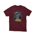 A Maroon tee showcasing an astronaut with a hitchhiker sign, by Apparel by Cetakshop, for the space wanderers.