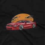 close up image of A Black tee with a classic car under a sunset design, from Apparel by Cetakshop, for vintage car lovers. The image shows a classic muscle car graphic tees.