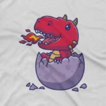 close up image of Red Dino Hatchling Tee by Apparel by Cetakshop. Kids' white t-shirt featuring a friendly red dino hatchling breathing fire, designed, ideal for adding a touch of fantasy to children's casual wear.