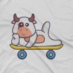 close up image of Cow On Skateboard Tee by Apparel by Cetakshop. Skateboarding Cow kids t-shirt design from Apparel by Cetakshop on a white tee.